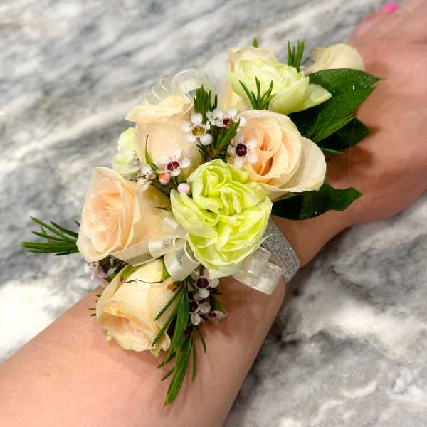 Wrist corsage with pale peach roses and light green blooms