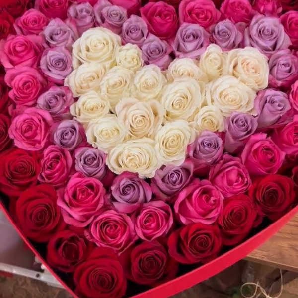 Heart-shaped box filled with red, pink, lavender, and white roses