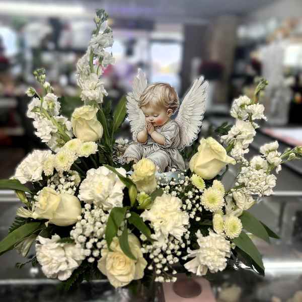 White floral arrangement with an angel figurine centerpiece