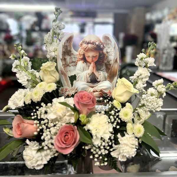 Pink and cream roses with white flowers around an angel card