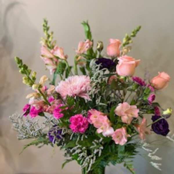 Mixed pink and purple flower arrangement in a clear glass vase