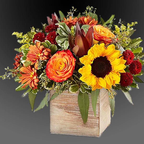 Mixed bouquet with sunflowers, orange roses, and red mums in a wooden box