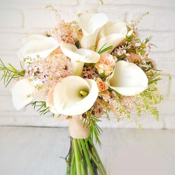 Bouquet of white calla lilies and pale peach roses