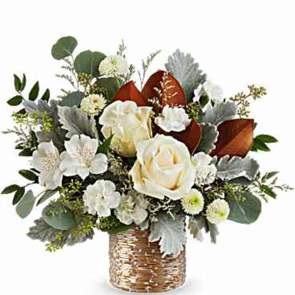 White roses and small white flowers in a woven basket vase