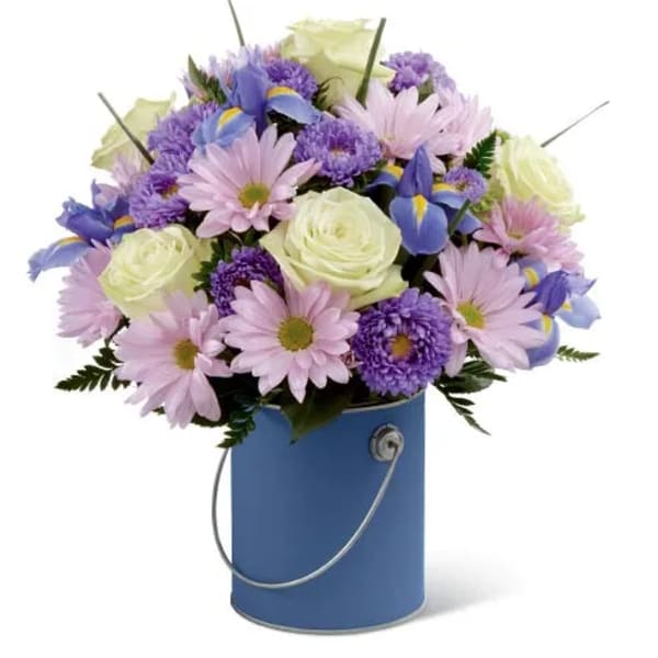 Bouquet of pastel flowers in a blue bucket vase