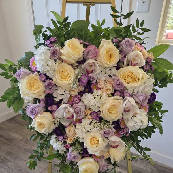 Heart-shaped floral arrangement with cream and lavender roses on a gold stand