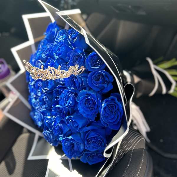 Bouquet of vivid blue roses wrapped in black and white paper