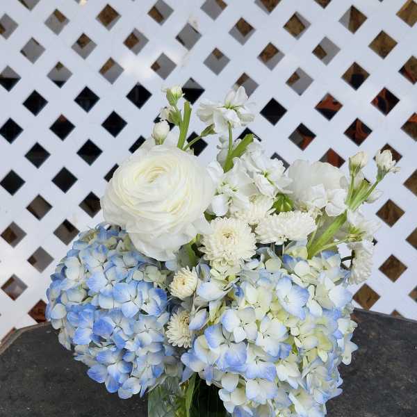 Blue and white flower arrangement in a glass vase