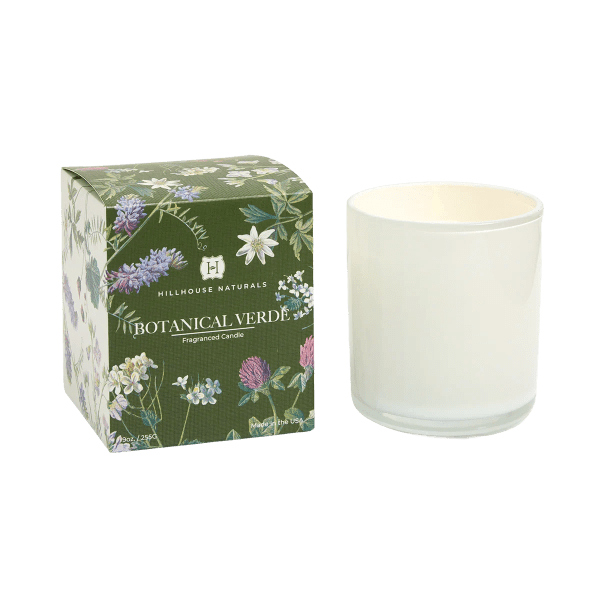 White glass candle next to a green botanical-printed box labeled Botanical Verde.