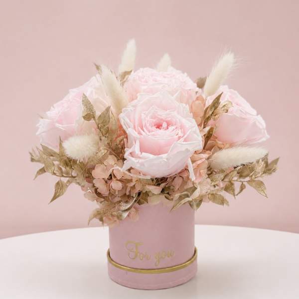 Pink rose arrangement in a round box with gold accents