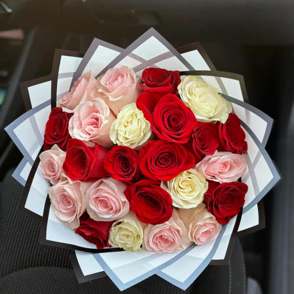 Bouquet of red, pink, and cream roses wrapped in layered paper