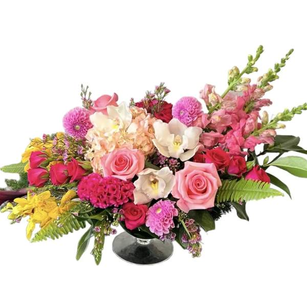 Mixed bouquet of pink, white, and yellow flowers in a glass vase