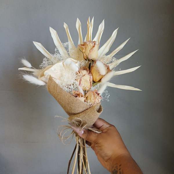 Small bouquet of dried cream roses wrapped in burlap