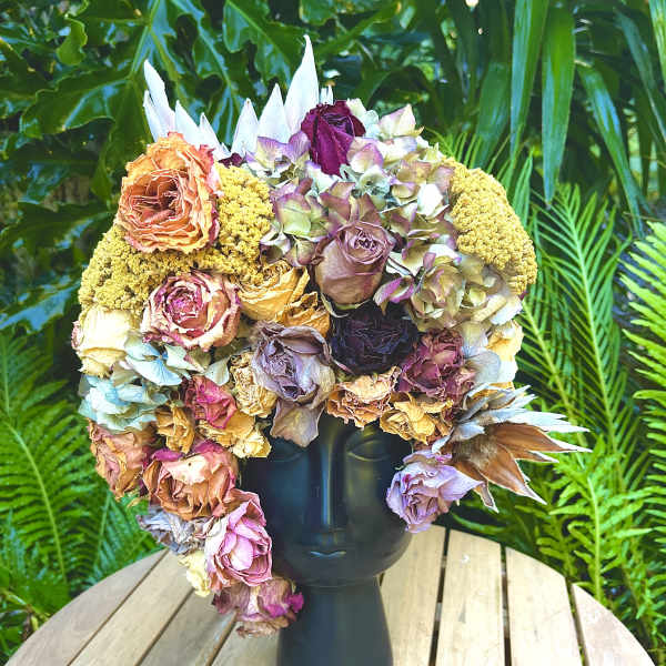 Large bouquet of dried roses and hydrangeas in a black vase