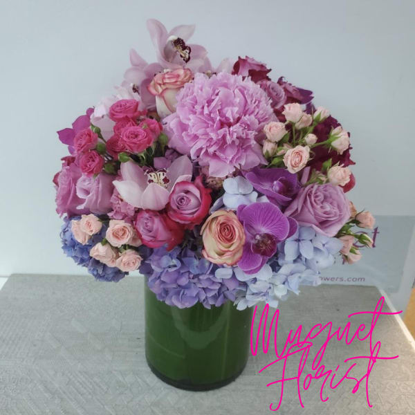 Mixed pink and purple bouquet in a green glass vase