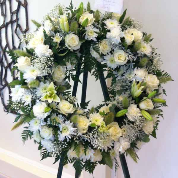 White floral wreath on a black easel