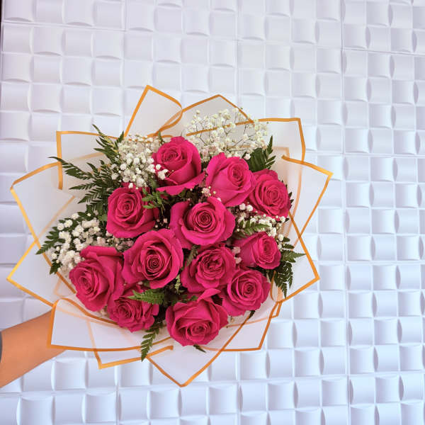 Handheld bouquet of hot pink roses with white baby's breath