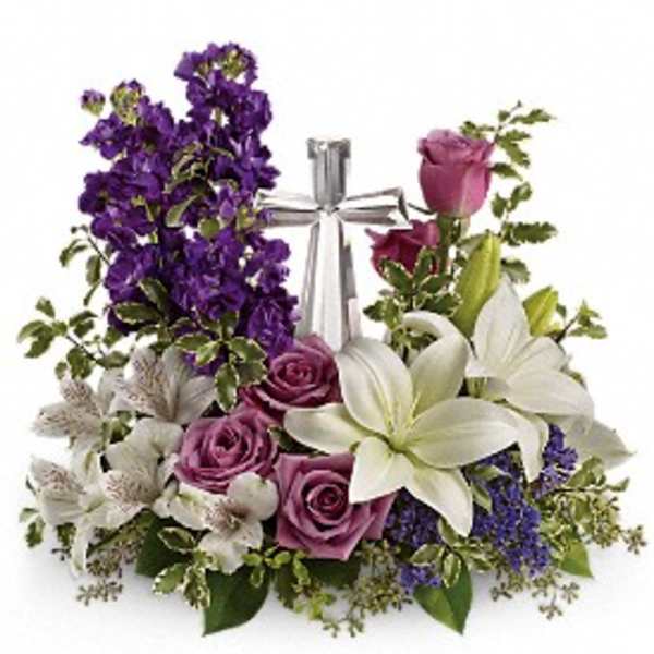 Arrangement of white lilies and lavender roses with purple flowers around a silver cross