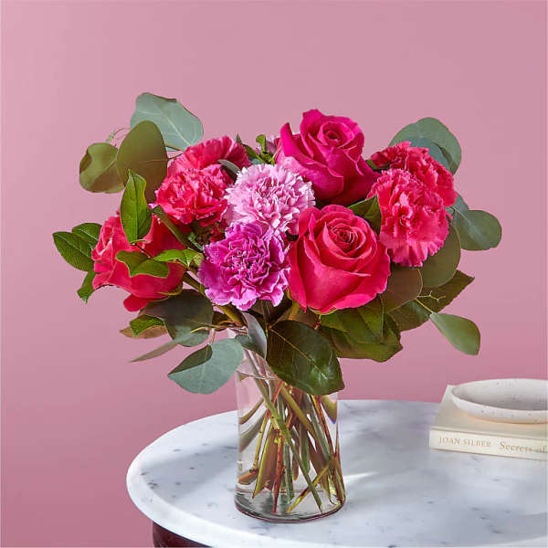 Pink roses and carnations in a clear glass vase