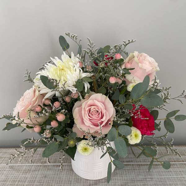 Pink roses and white chrysanthemums in a white vase
