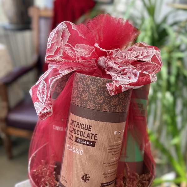 Gift basket with a cocoa mix tin wrapped in red mesh ribbon