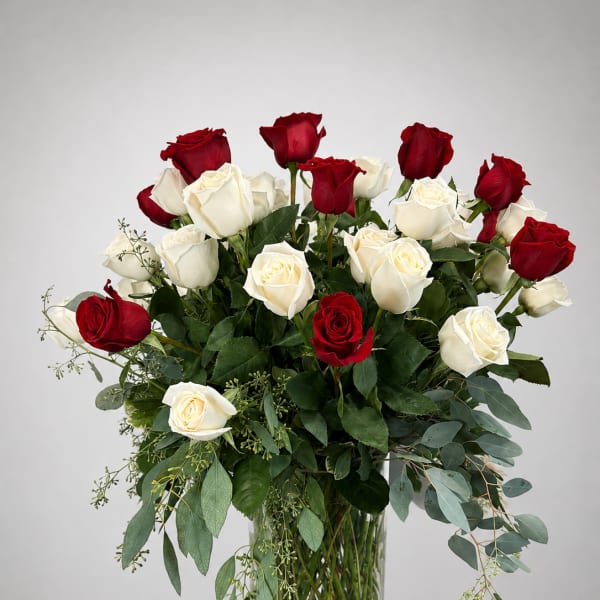 Red and white roses arranged in a clear glass vase
