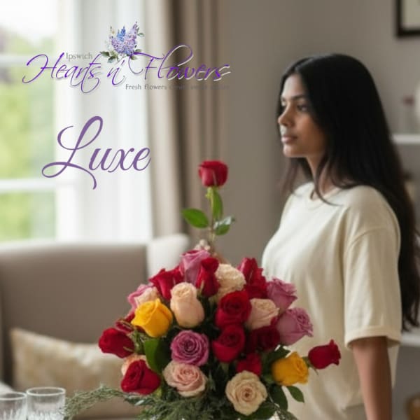Mixed rose bouquet in a clear glass vase on a set dining table