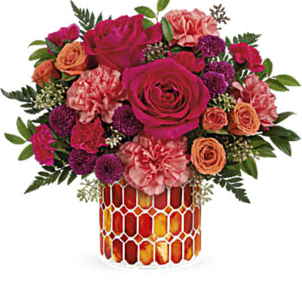 Pink and orange roses with carnations in a mosaic glass vase