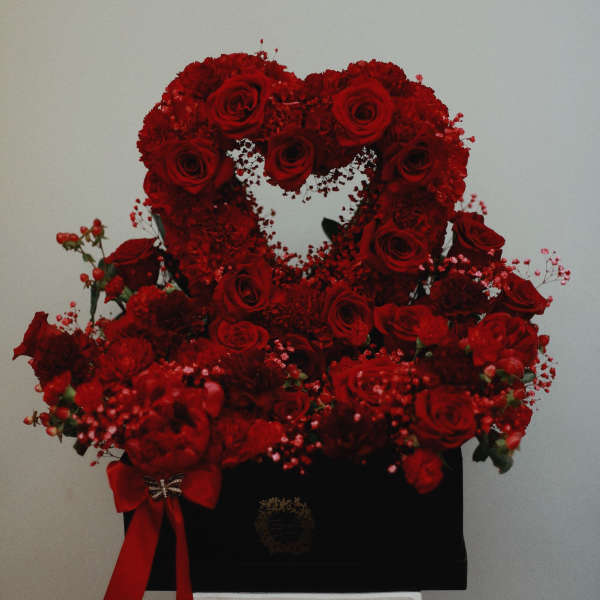 Red rose heart arrangement in a black box with a red ribbon