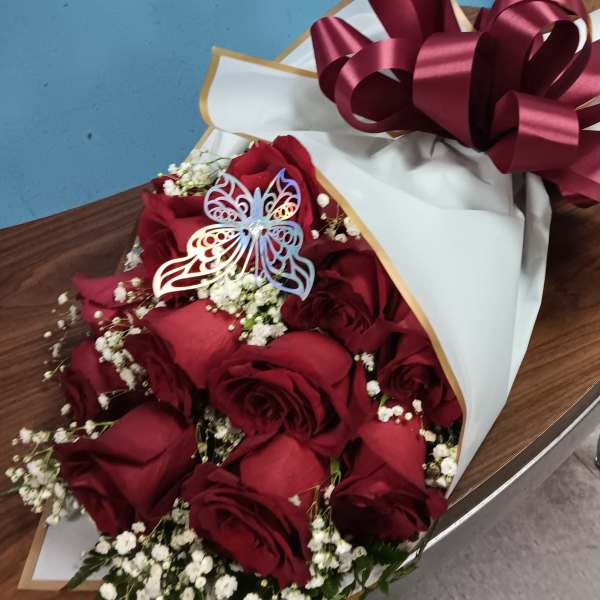 Bouquet of red roses with baby's breath in white wrapping