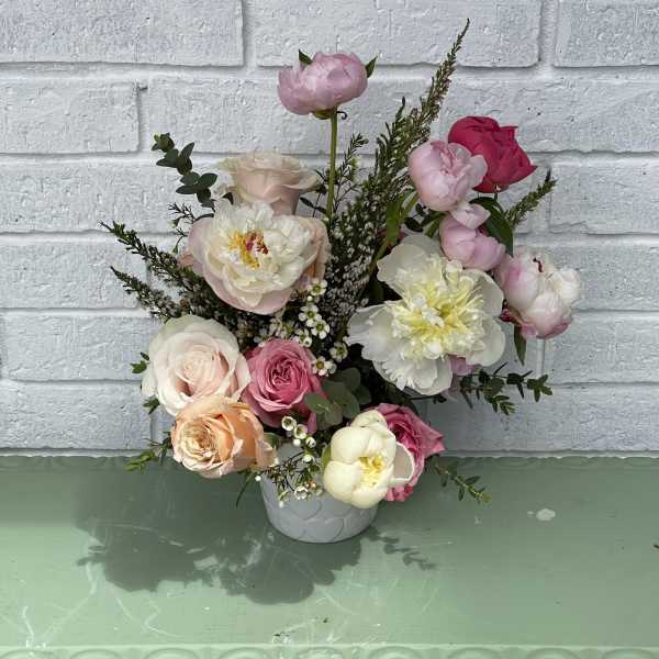 Mixed pink and white floral arrangement in a white vase