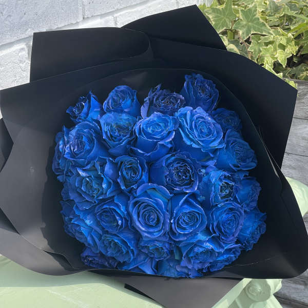Bouquet of vivid blue roses wrapped in black paper
