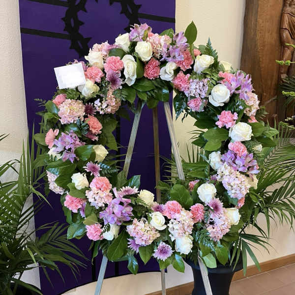 Large floral wreath on an easel with pink, white, and lavender flowers