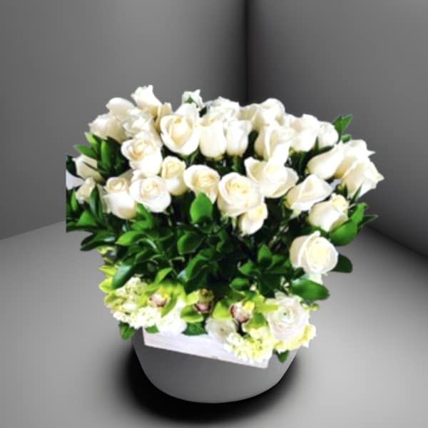 White rose arrangement in a round gray vase