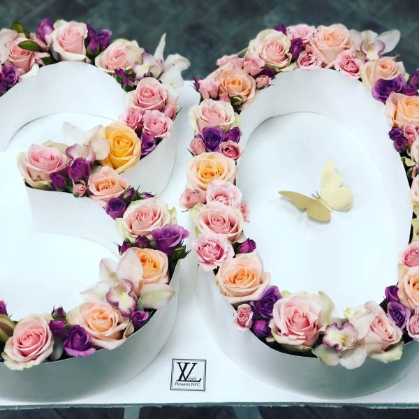 Floral arrangement shaped like the number 80 with pink, peach, and purple roses