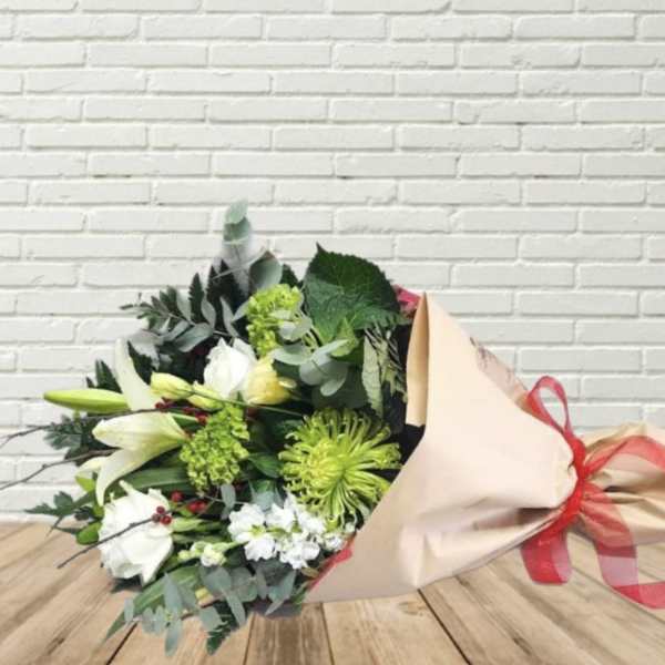 Bouquet of white lilies and green chrysanthemums wrapped in beige paper with a red ribbon