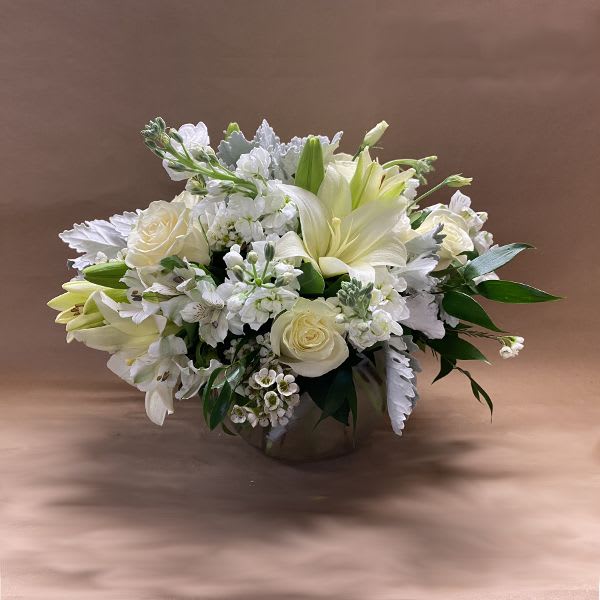 White floral arrangement in a low round container