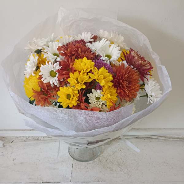 Bouquet of mixed daisies and chrysanthemums in white, yellow, orange, and red