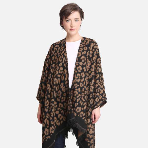 Woman modeling a brown and black leopard print poncho with fringe hem