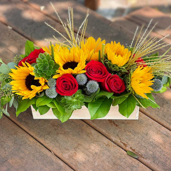 Sunflowers and red roses arranged in a white rectangular box