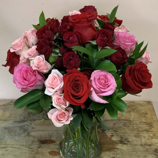 Bouquet of red and pink roses in a clear glass vase