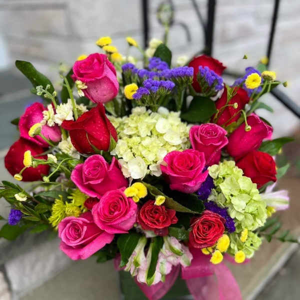Bouquet of pink and red roses with white and purple filler flowers