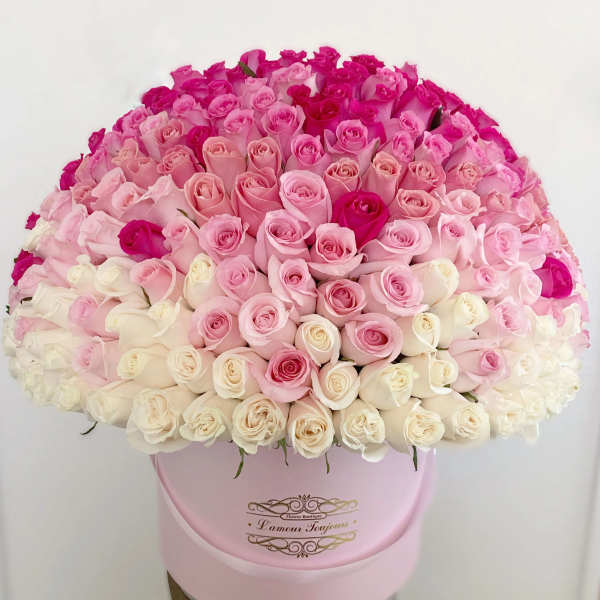 Large dome of white and pink roses arranged in a round pale pink hat box