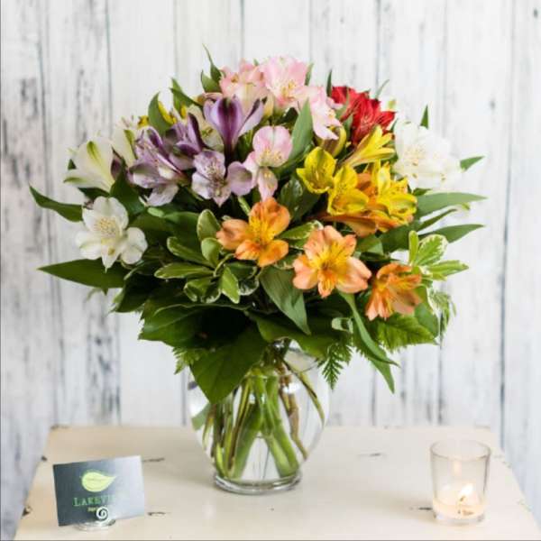 Mixed bouquet of colorful flowers in a clear glass vase
