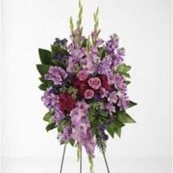 Standing floral spray with purple and pink flowers on an easel