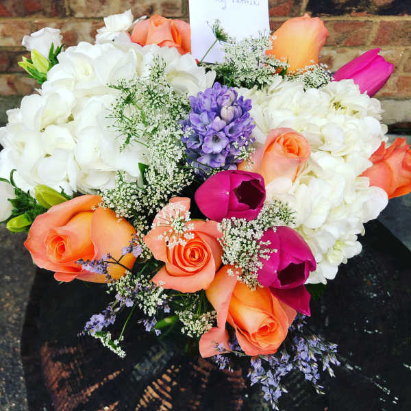 Bouquet of white hydrangeas with orange, pink, and purple flowers