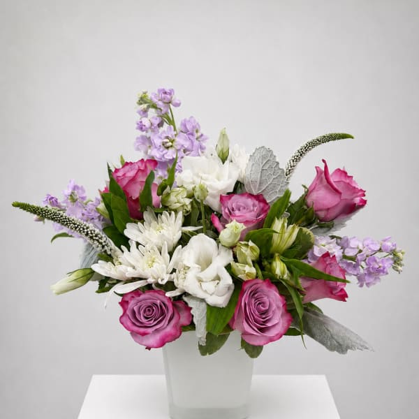 Pink and white mixed flower arrangement in a square white vase