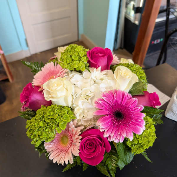 Bouquet of pink and white roses, gerbera daisies, and green hydrangeas