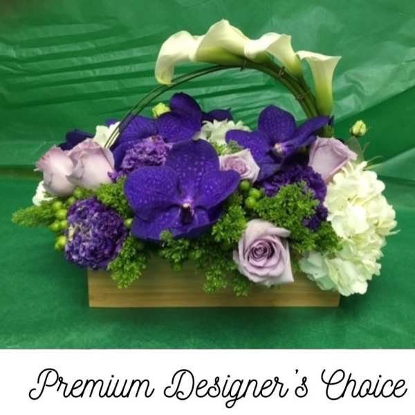 Purple and white floral arrangement in a wooden basket with arched calla lilies