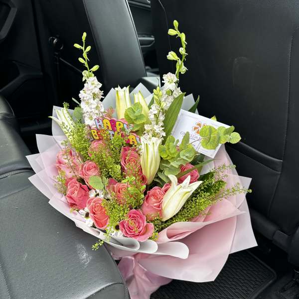 Pink rose bouquet with white lilies and a birthday topper